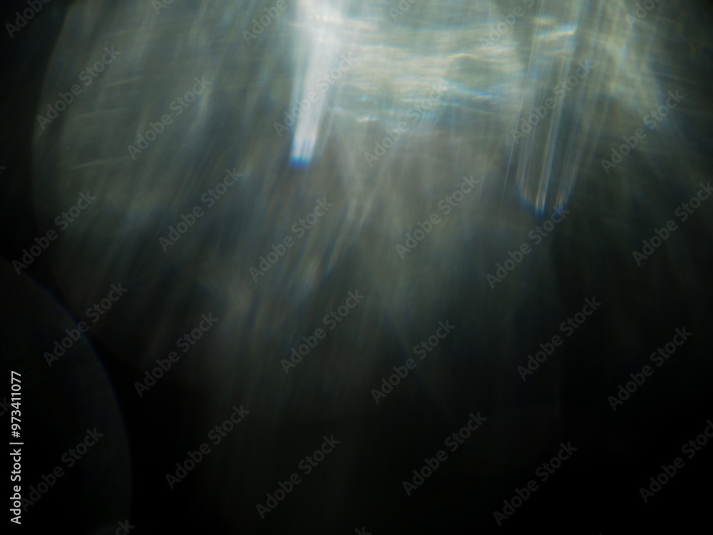 Wall mural a blurry image of a light flare with a dark background. the image has a moody and mysterious feel to