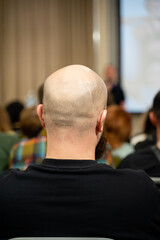 An audience member at a conference is showing genuine engagement and attentiveness to the discussions and presentations taking place