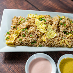 chaufa rice with chicken chunks, accompanied by homemade creams