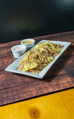 chaufa rice with chicken chunks, accompanied by homemade creams