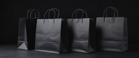Four Black Shopping Bags on a Dark Surface