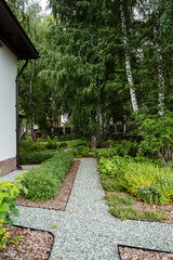 A scenic path leads to a lovely house in a garden surrounded by trees