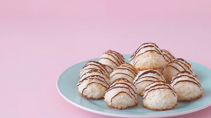 Coconut macaroons drizzled with chocolate on a pastel pink plate. Studio food photography on a pink background. Design for bakery, dessert menu, or poster.

