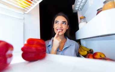 What to cook. Pensive girl looking into refrigerator, thinking about lunch recipe, view from inside