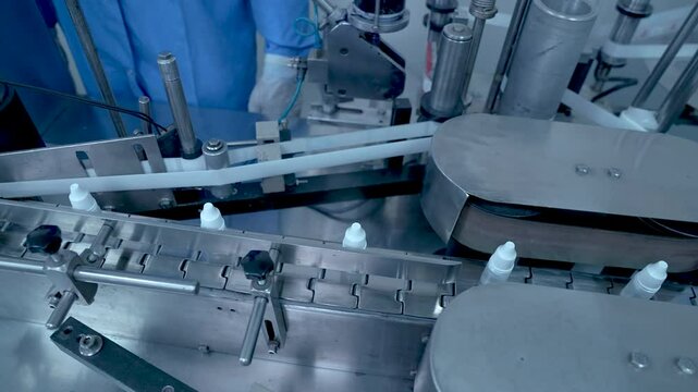 eye drop manufacturing. Ophthalmic drops solution, eye ear drop making process in factory. eye drop medicine in plastic bottles on conveyor belt. production of medical drops in a pharmaceutical line	