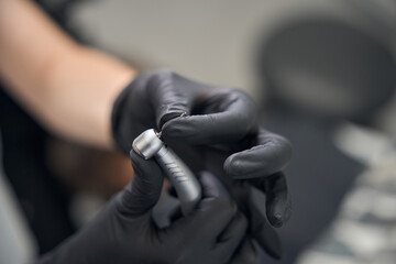 Doctor inserts a bur into a dental drill