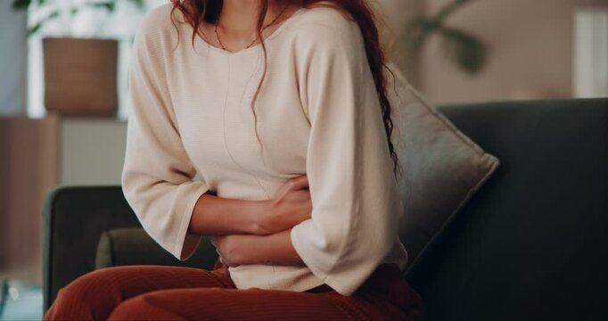 Woman, stomach and pain with discomfort or cramps in food poisoning, indigestion and bloating in home. Female person, tummy ache and gut health with abdominal muscle strain, menstrual cycle or nausea