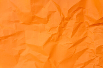 Top view and full frame of wrinkled or crumpled orange paper texture used as crumpled paper background texture in decorative art work.