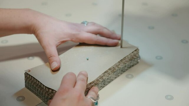 Close-up of a woman's hands making a professional cut of fabric with a cutting machine. Textile factory, garment production and new technologies. High quality 4k footage