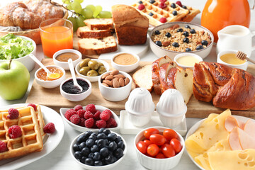 Different meals served for breakfast on white table