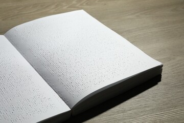 Book with Braille text on wooden table. Education and leisure for blind people