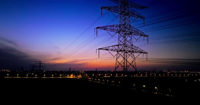 Aerial shot of high voltage electricity towers at dusk