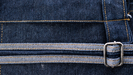 A closeup of blue denim jeans featuring a zipper, showcasing the detailed texture and stitching of...