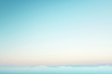 Fototapeta premium Pastel colored sky fading into white over a layer of fog
