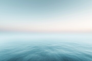 Fototapeta premium Calm ocean water merging with foggy sky at sunset