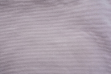Close-up of beige denim jeans fabric with visible texture and back pocket detail