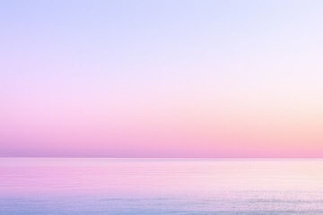Pastel pink and purple sunset fading into calm ocean water