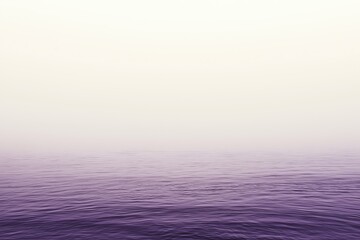 Purple sea merging with misty sky on the horizon