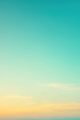 Obraz premium Turquoise and yellow gradient sky with clouds forming at sunset
