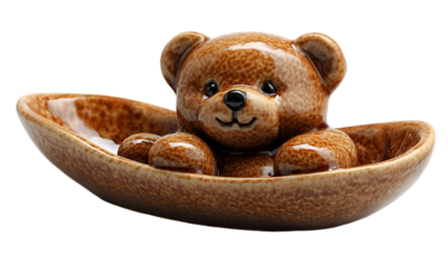 a small brown teddy bear in a bowl. 