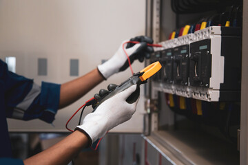 Electrical and electricity service technician checking electric current voltage at circuit breaker...