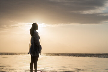 Silhouette of a Woman at Sunset by the Water