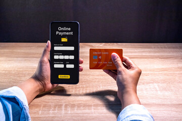 Woman holding credit card and using smartphone to make online payment. Online shopping or...