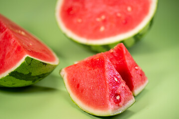 The watermelon and the sliced watermelon piece in green background