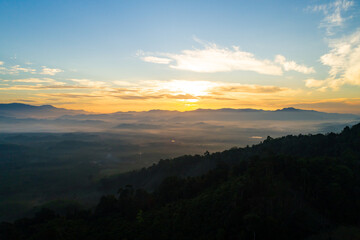 Obraz premium Amazing Sunrise or sunset over mountains hills covered with mist, Aerial view landscape drone shot beautiful colorful nature background