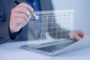 Businessman marking the schedule. Businessman using laptop computer create a calendar program, rganize and schedule activity and event planner, a calendar page shows on virtual laptop, scheduler, date
