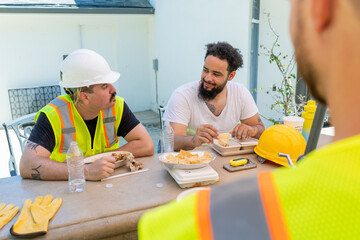 Two dedicated construction workers in safety gear take a break to engage in a lively discussion...