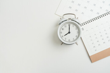 close up of calendar and alarm clock on the white table background, planning for business meeting or travel planning concept