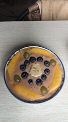A plate of bananas, blueberries, and grapes on a table