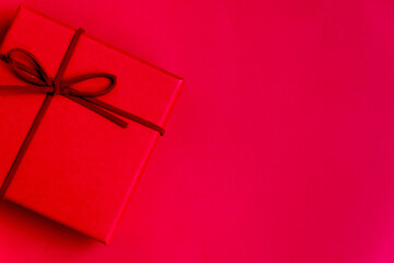 Single red gift box with space for text on red background. Christmas supplies