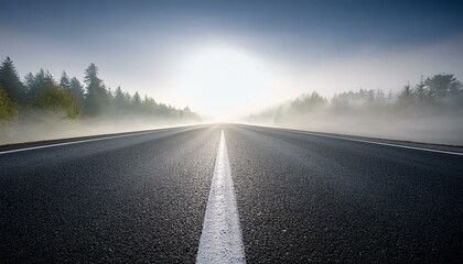 Asphalt road vanishing into foggy haze with highlighted center line