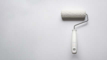 Obraz premium Paint roller on a white background. Tool for painting and home renovation. Minimalist style. Concept of DIY and home improvement projects.