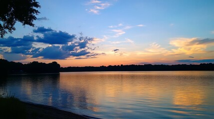 Fototapeta premium A serene evening sky just before dusk, with deep blue fading into warm amber tones and gentle clouds drifting by