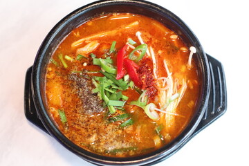 A steaming bowl of spicy Korean rice topped with vegetables and savory broth. The rich, fiery flavor is perfect for a comforting and satisfying meal.