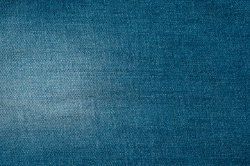 Denim fabric texture in vibrant blue color showcasing woven patterns and subtle variations