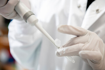 Close up of scientist pipetting into a microcentrifuge vile