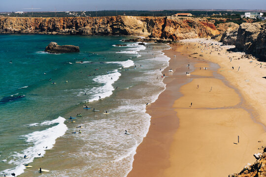 Surfers on the waves at Praia do Tonel in Sagres, Algarve, Portugal.