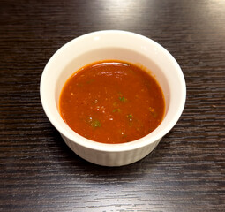 Tomato sauce on a white plate on the table