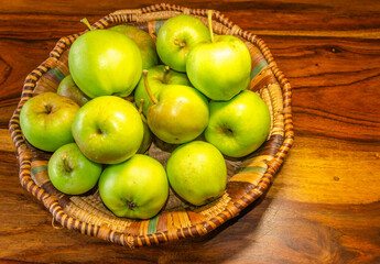 Close-up of green apples in a woven wicker basket