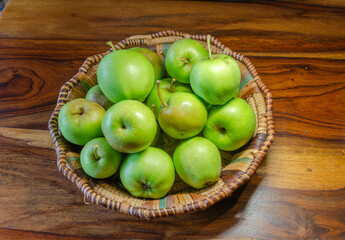 Close-up of green apples in a woven wicker basket