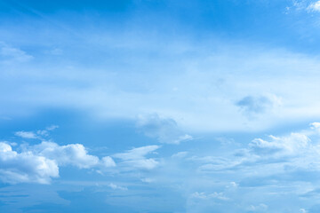Beautiful fluffy white clouds drift across a bright blue sky