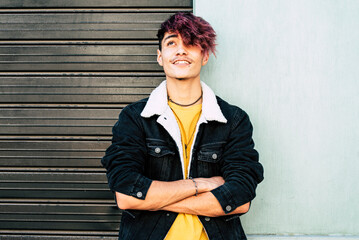 Portrait of a trendy and alternative teenage boy with a thoughtful expression, embodying...