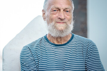 Portrait of an elderly man smiling in the park during his leisure time. This mature gentleman exudes serenity and happiness, showcasing a healthy and fulfilling lifestyle while embracing the joys