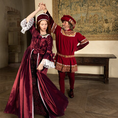Medieval Renaissance couple dancing in ballroom