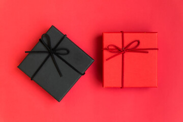 Red and black gift box with ribbon. top view of gift box on red background. greeting cards, advertisements, christmas celebration parties