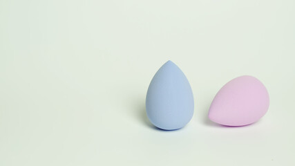 Two colored beauty blenders on a light background